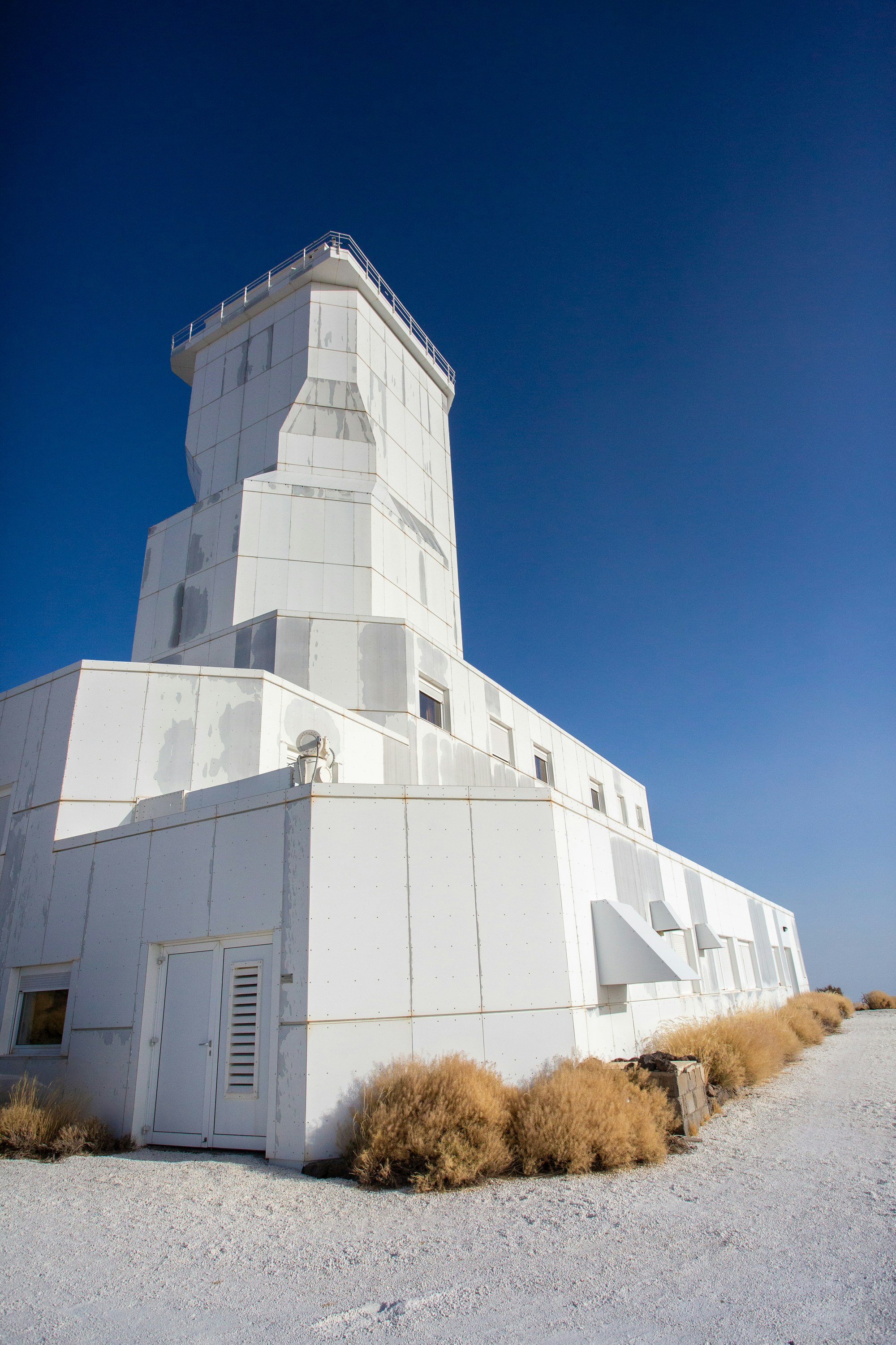 a tall white building sitting on the side of a road