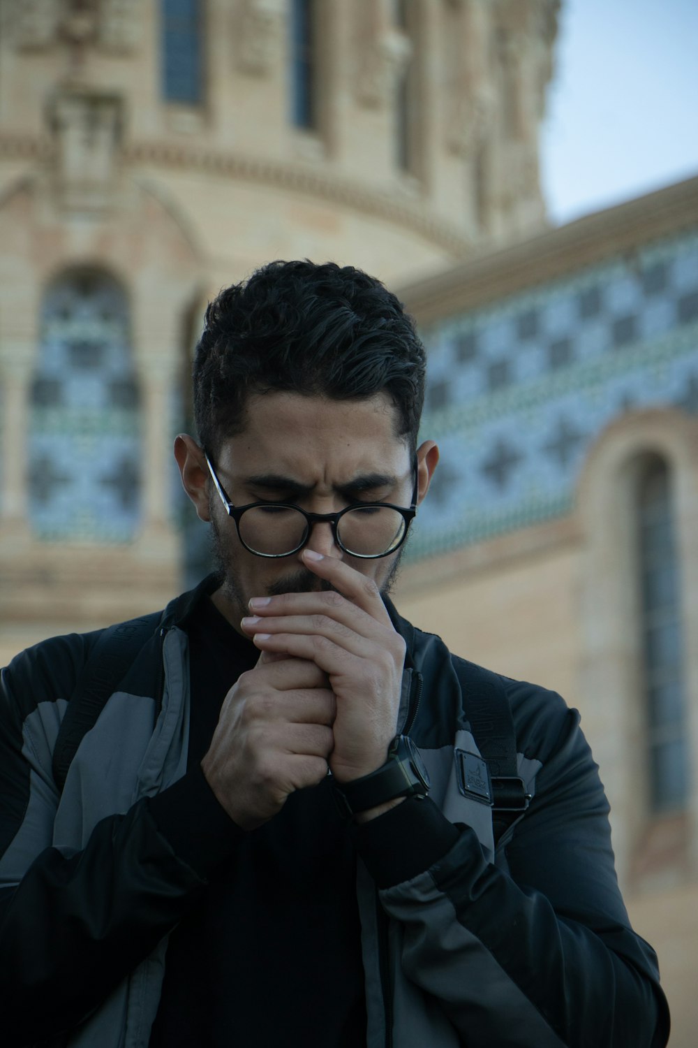 a man wearing glasses is looking at his cell phone