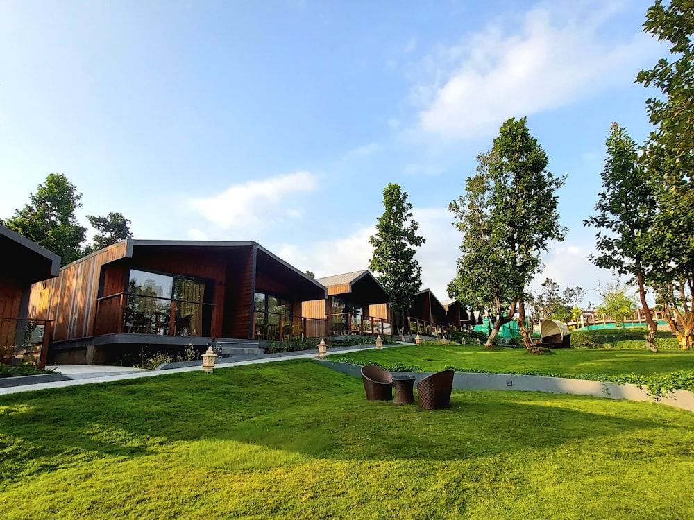 a grassy area with benches and trees in the background