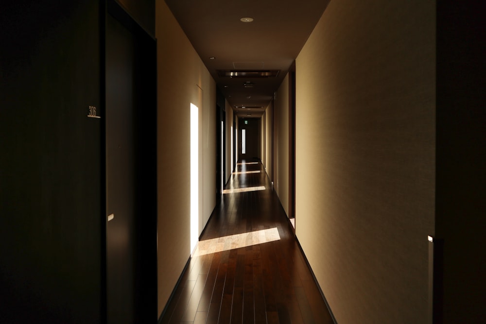 a long hallway with a wooden floor and light coming through the windows
