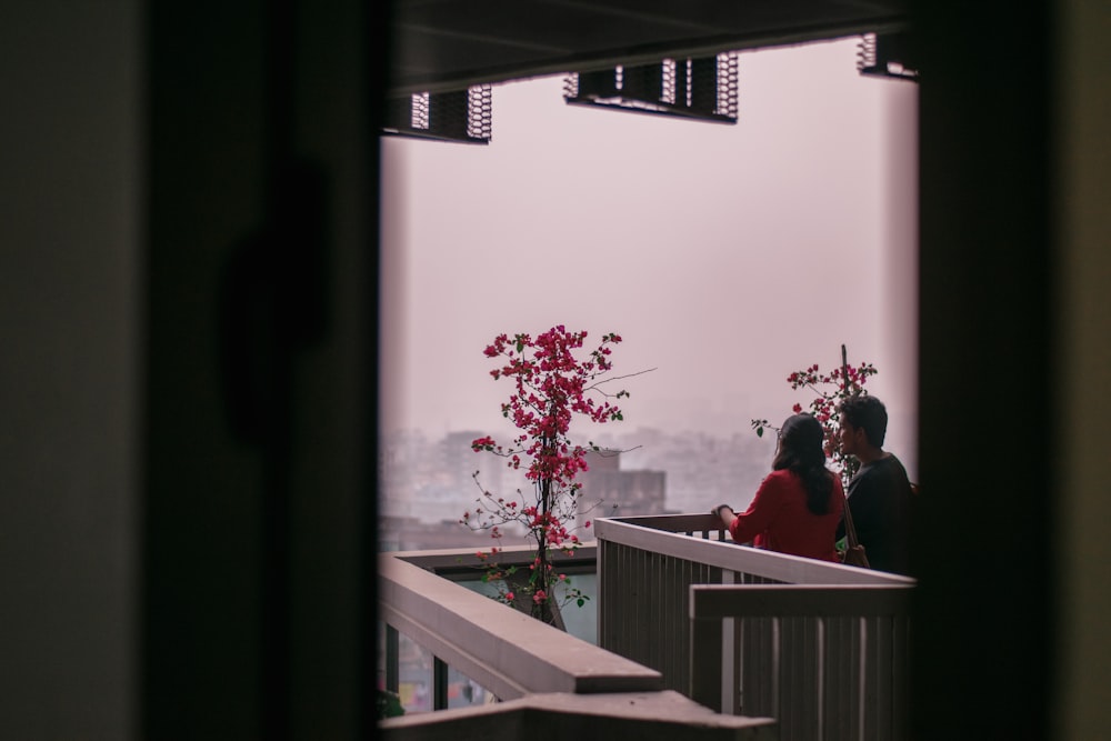 a couple of people standing on top of a balcony