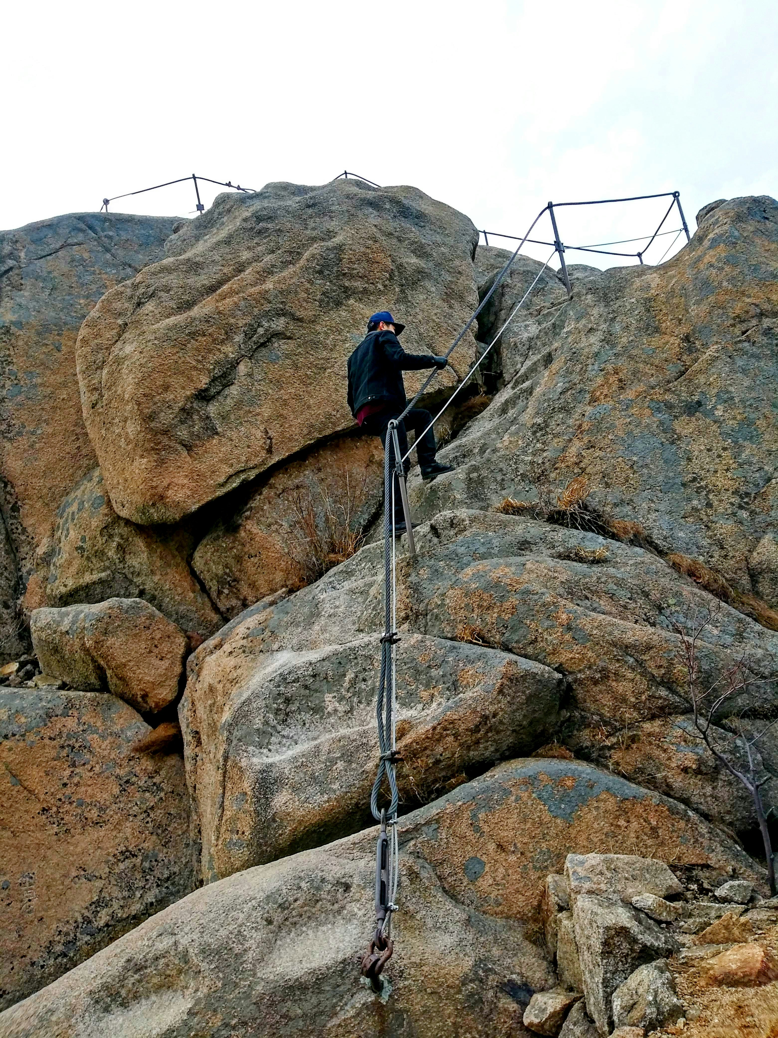 A man climbing up the side of a mountain photo – Free Man Image on Unsplash