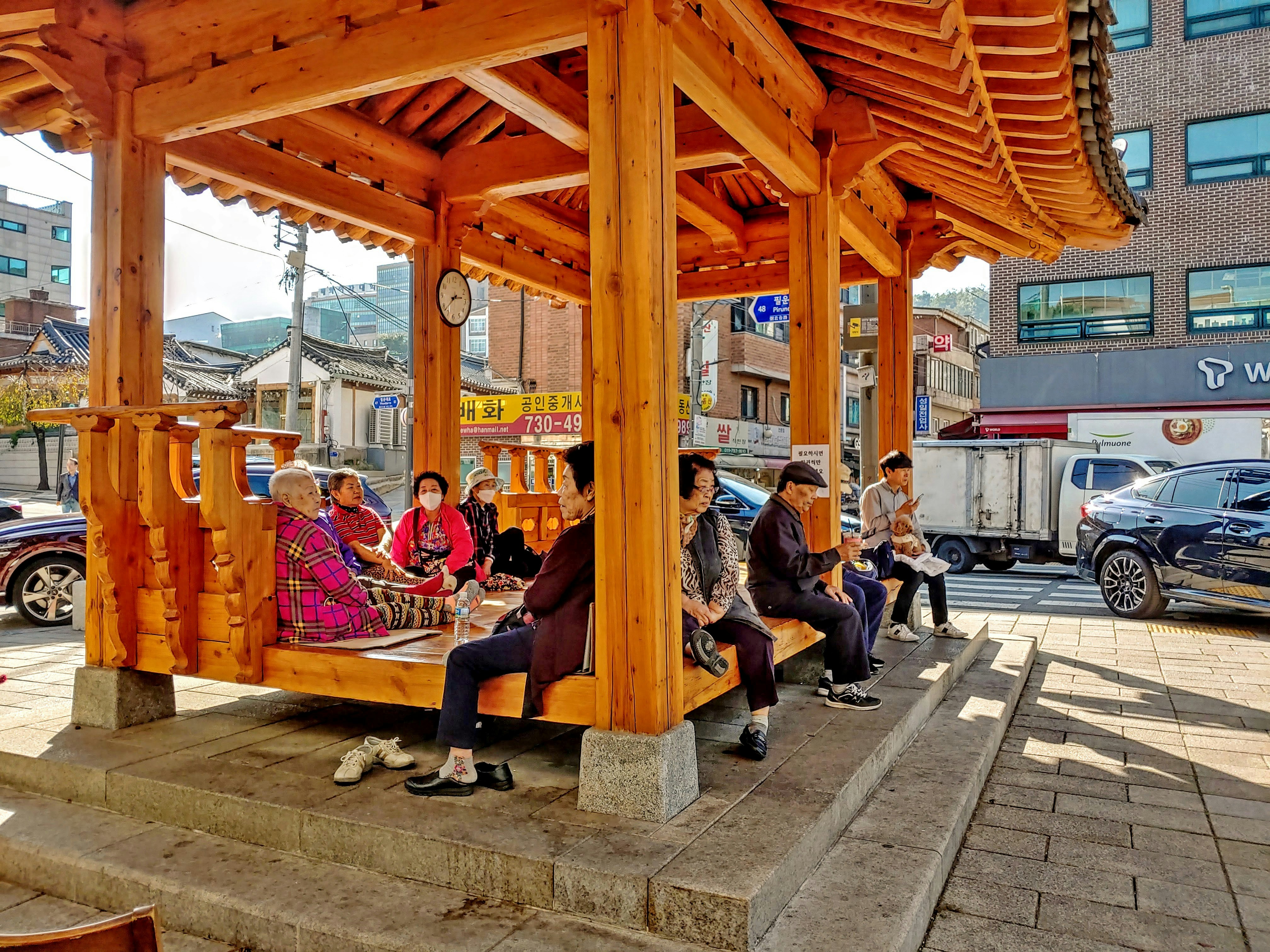 a group of people sitting under a wooden structure