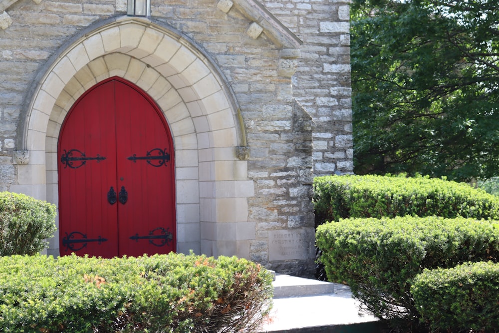 a red door in front of a stone building