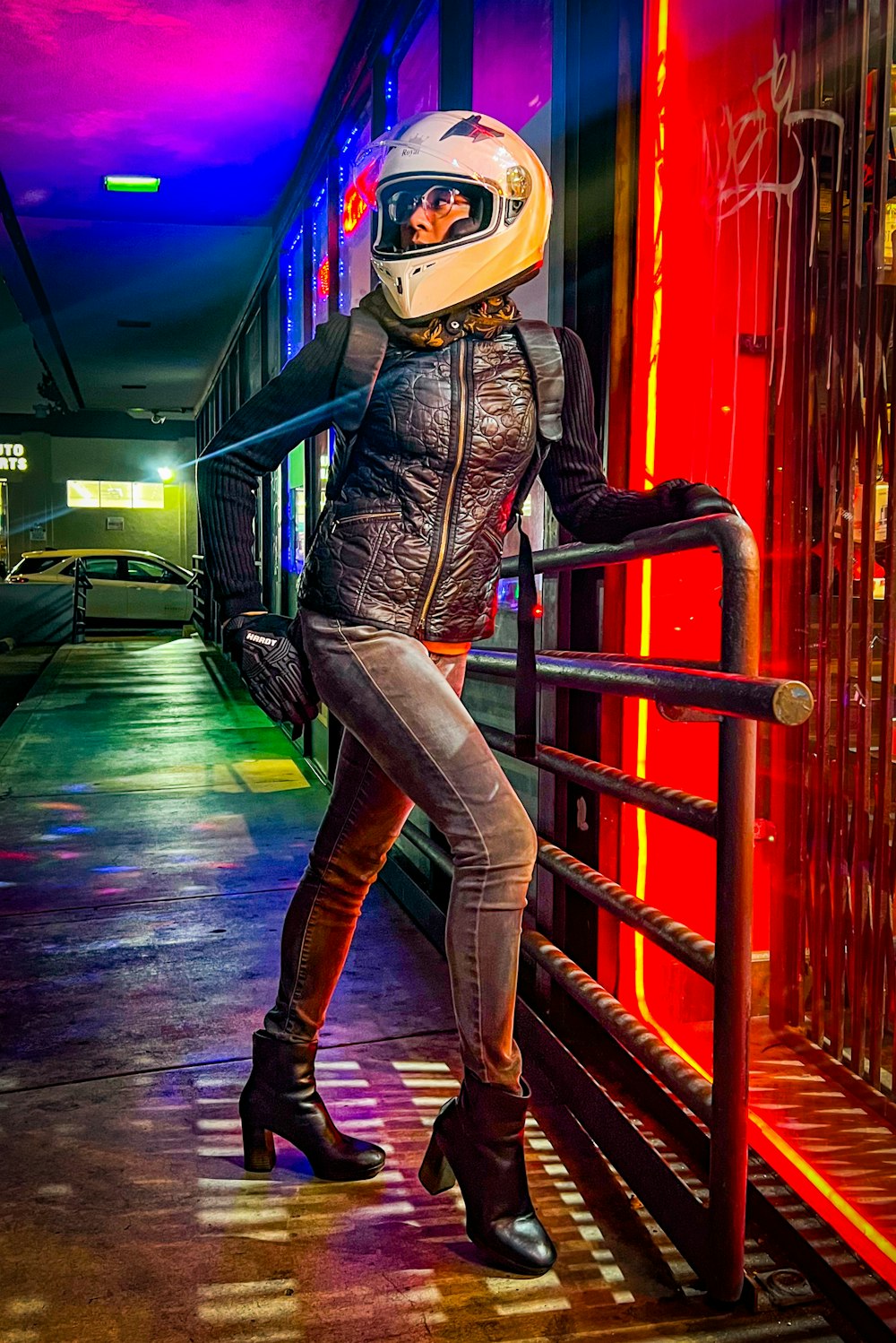 a woman in a helmet leaning on a rail