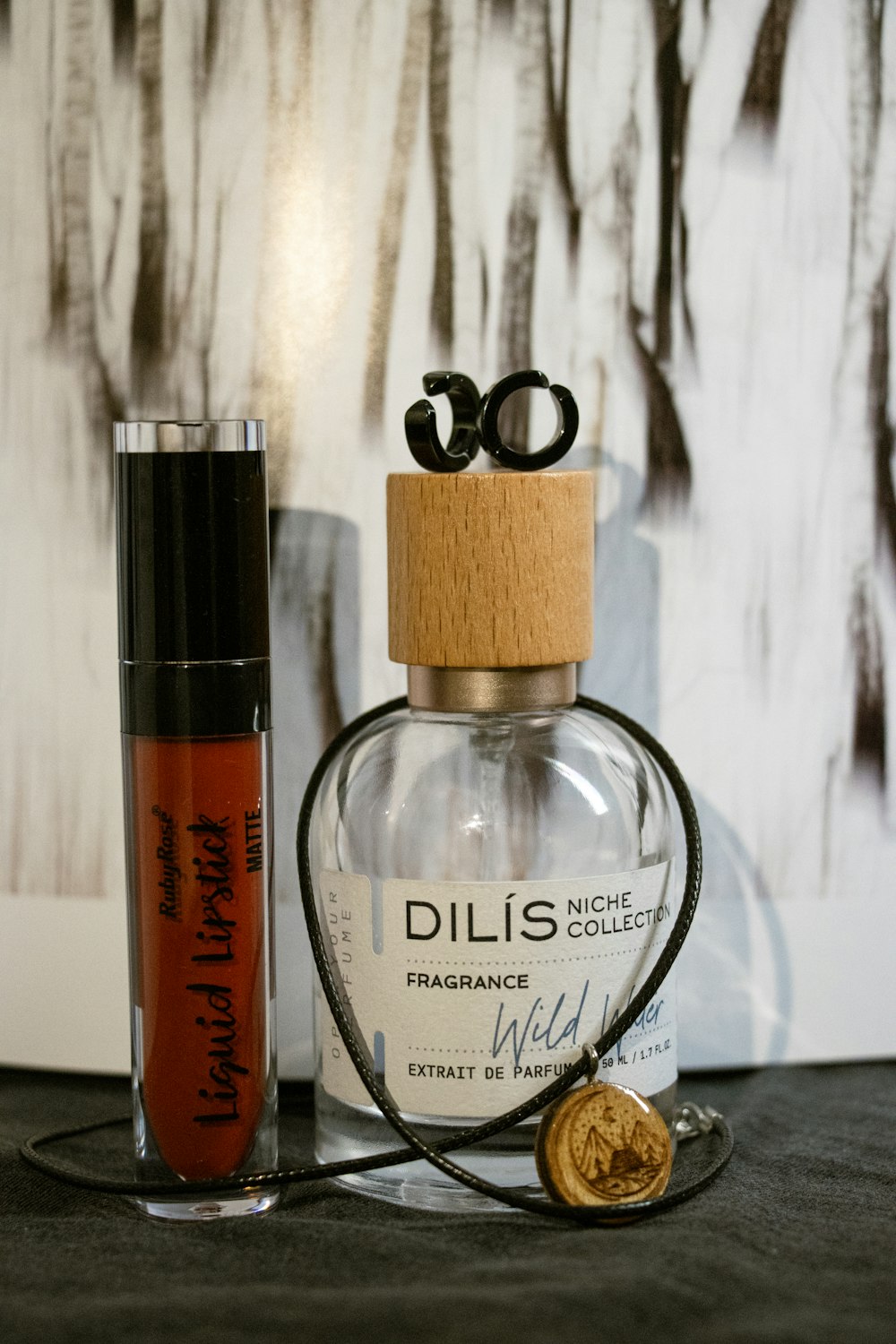 a bottle of perfume next to a bottle of lipstick