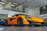 a bright orange sports car in a showroom