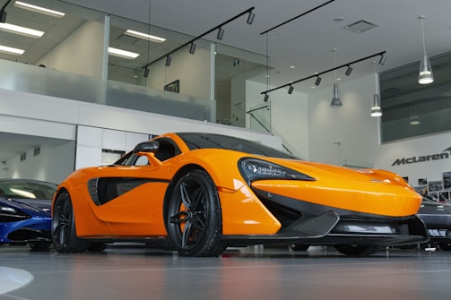 a bright orange sports car in a showroom