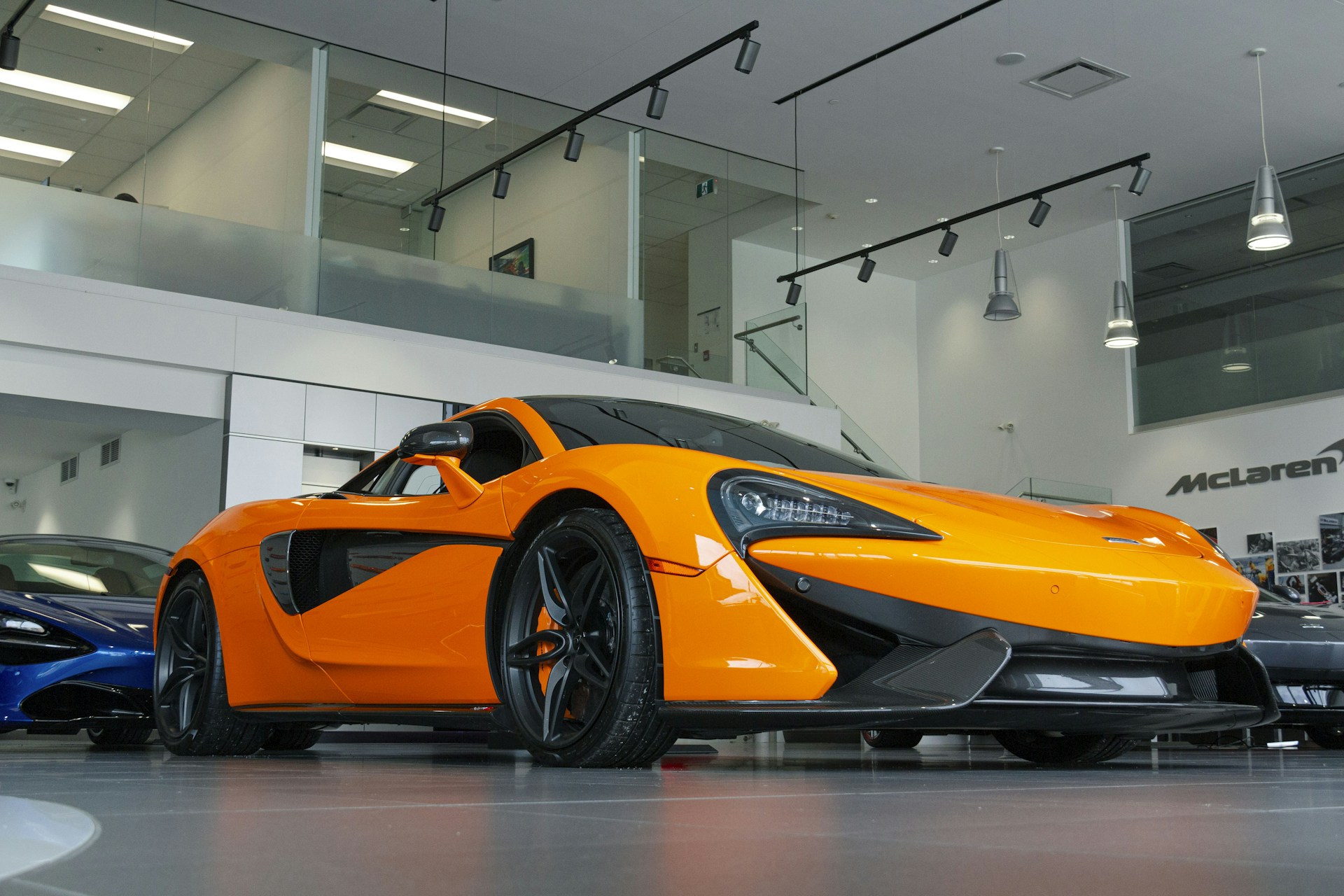 a bright orange sports car in a showroom