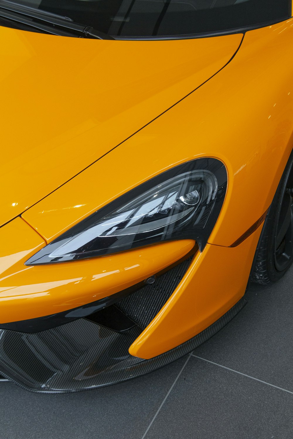 a close up of the front of a yellow sports car