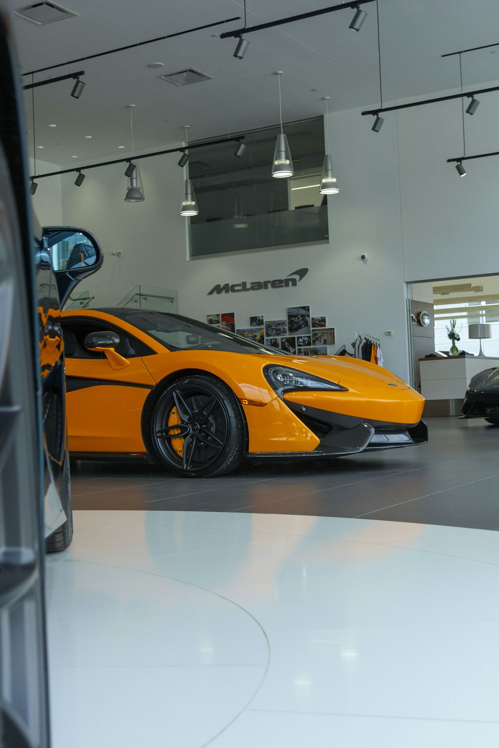 an orange sports car parked in a showroom