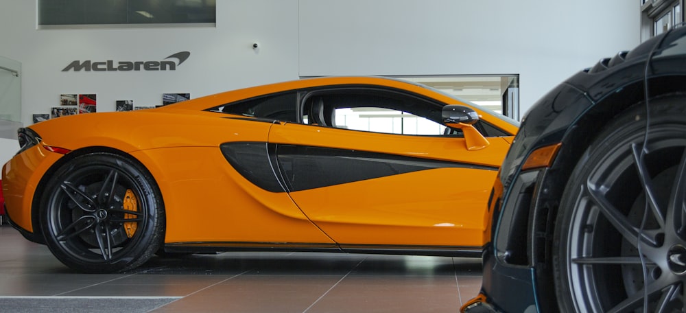 a bright orange sports car parked in a garage