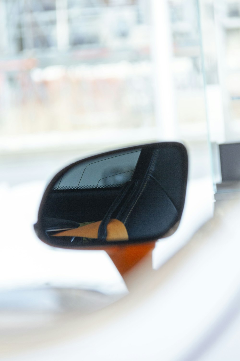 a side view mirror on a car with a building in the background