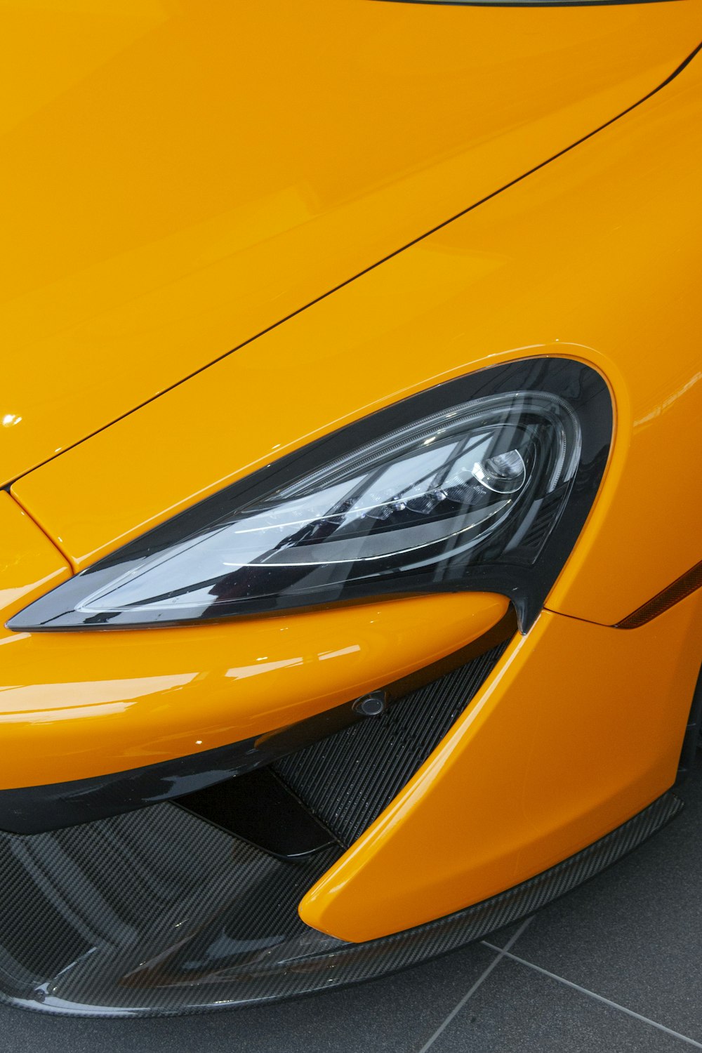 a close up of the front of a yellow sports car