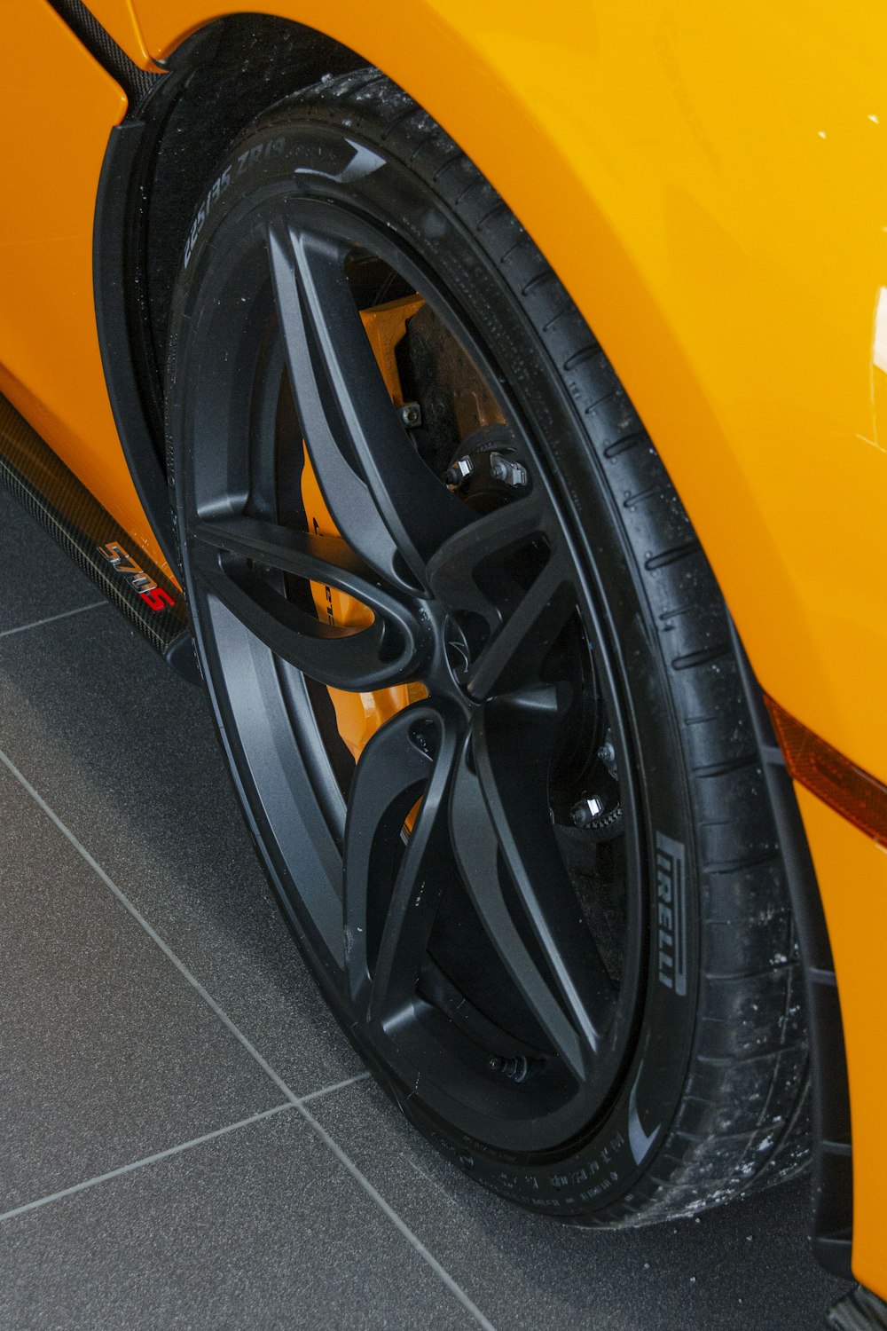 a close up of a yellow sports car tire