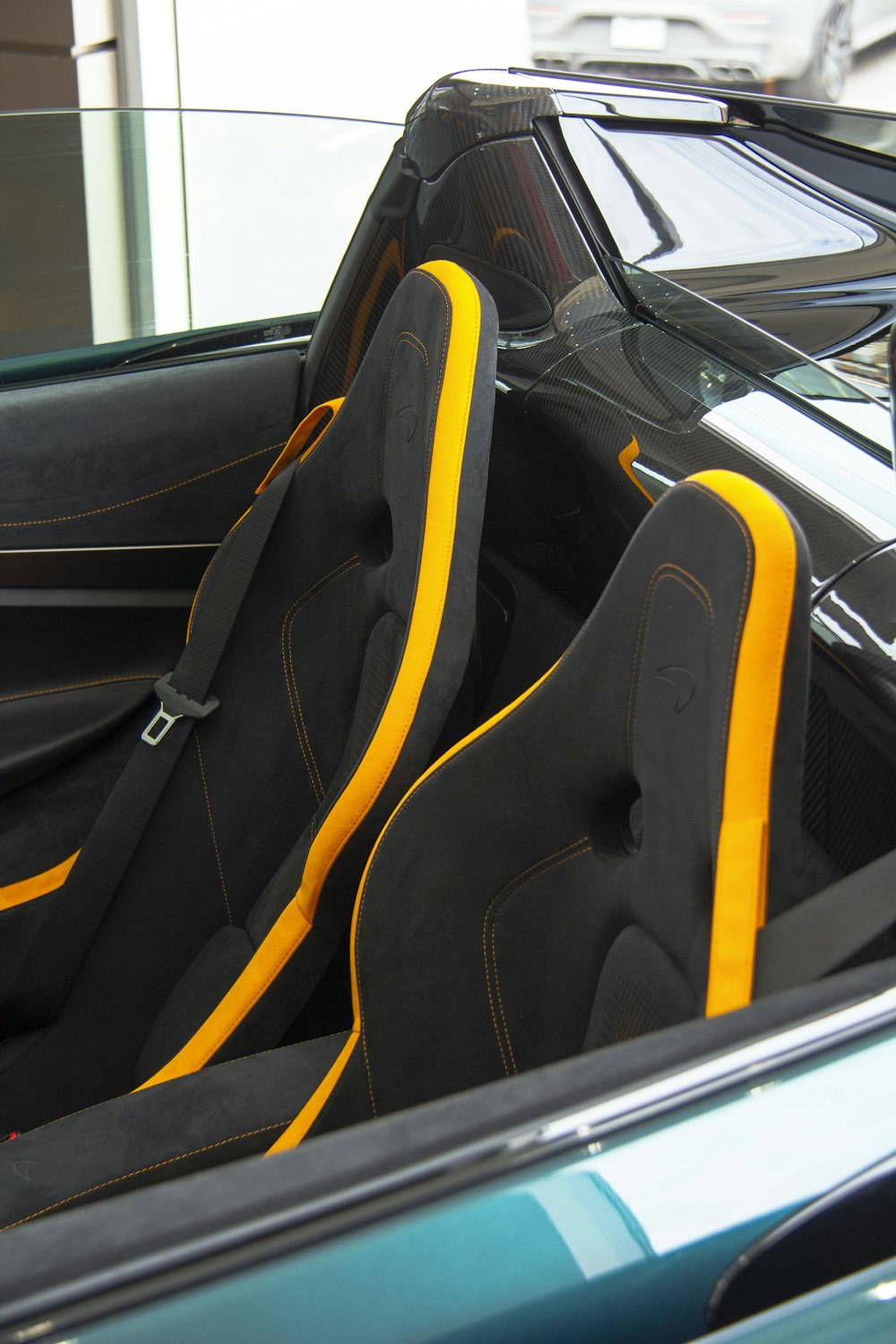 the interior of a sports car with yellow stitching