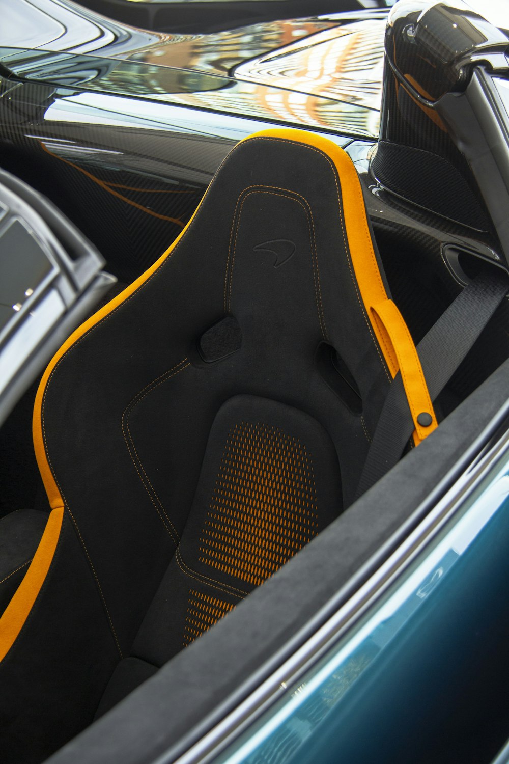 the interior of a sports car with yellow stitching