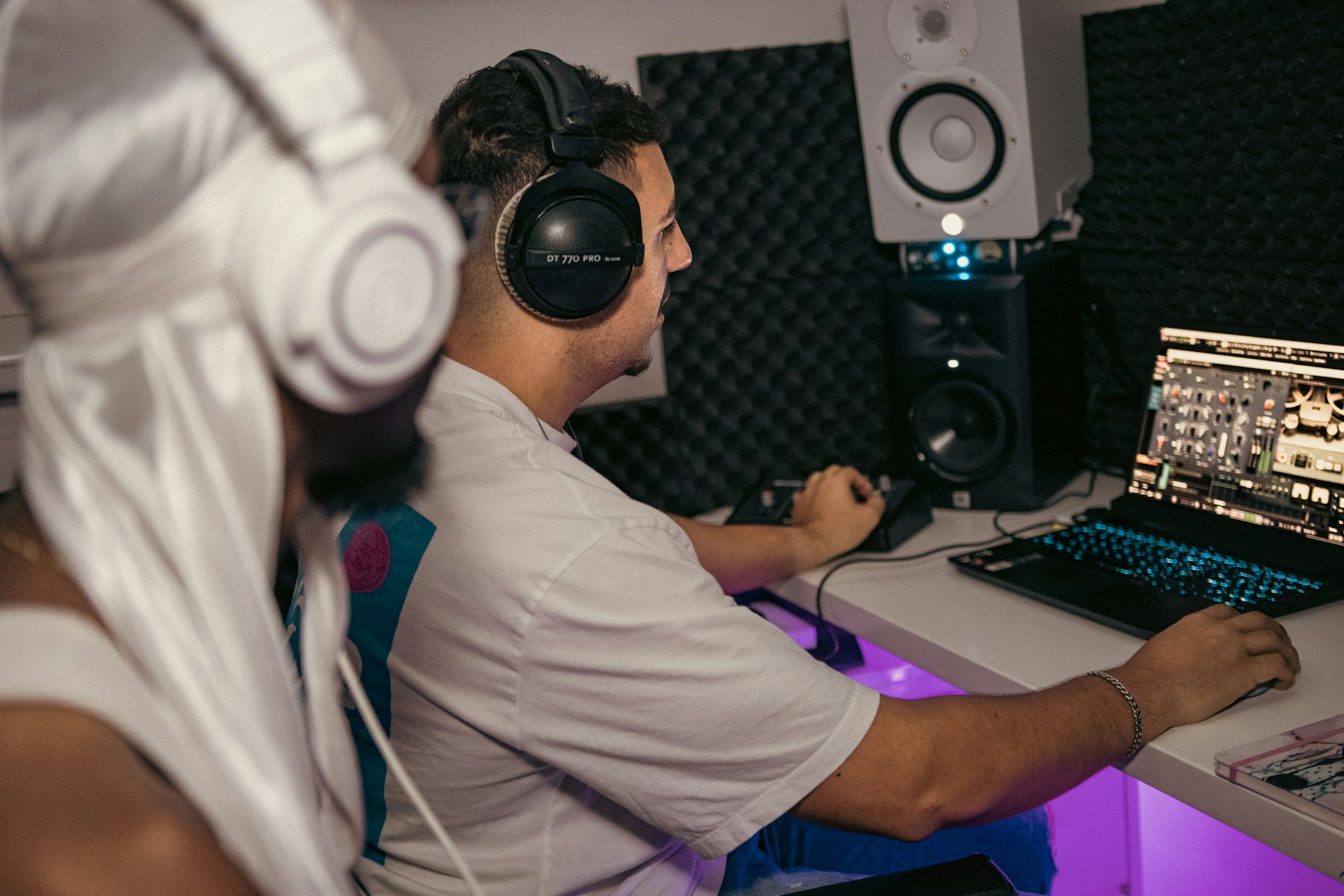 a man wearing headphones sitting in front of a laptop computer