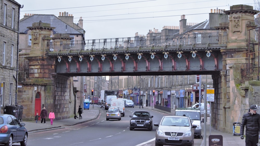 a bridge over a street with cars driving under it