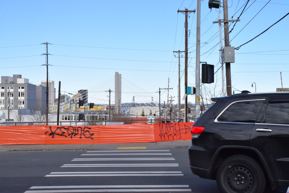 a black jeep driving down a street next to a traffic light