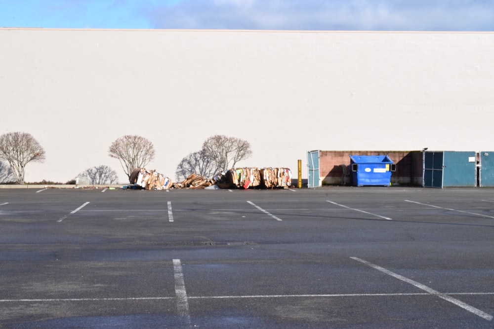 a parking lot with a white building and trees