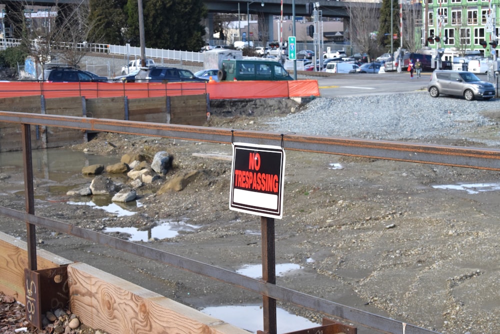 a no trespassing sign on a fence near a construction site