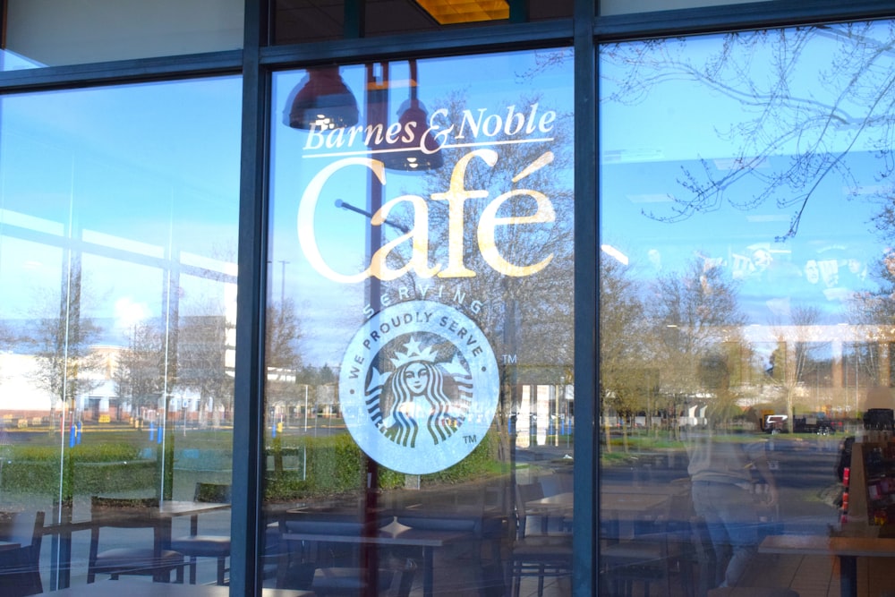 a starbucks sign is reflected in the window of a cafe