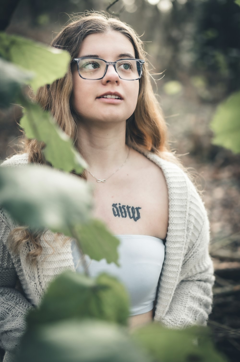 a woman with glasses and a tattoo on her chest