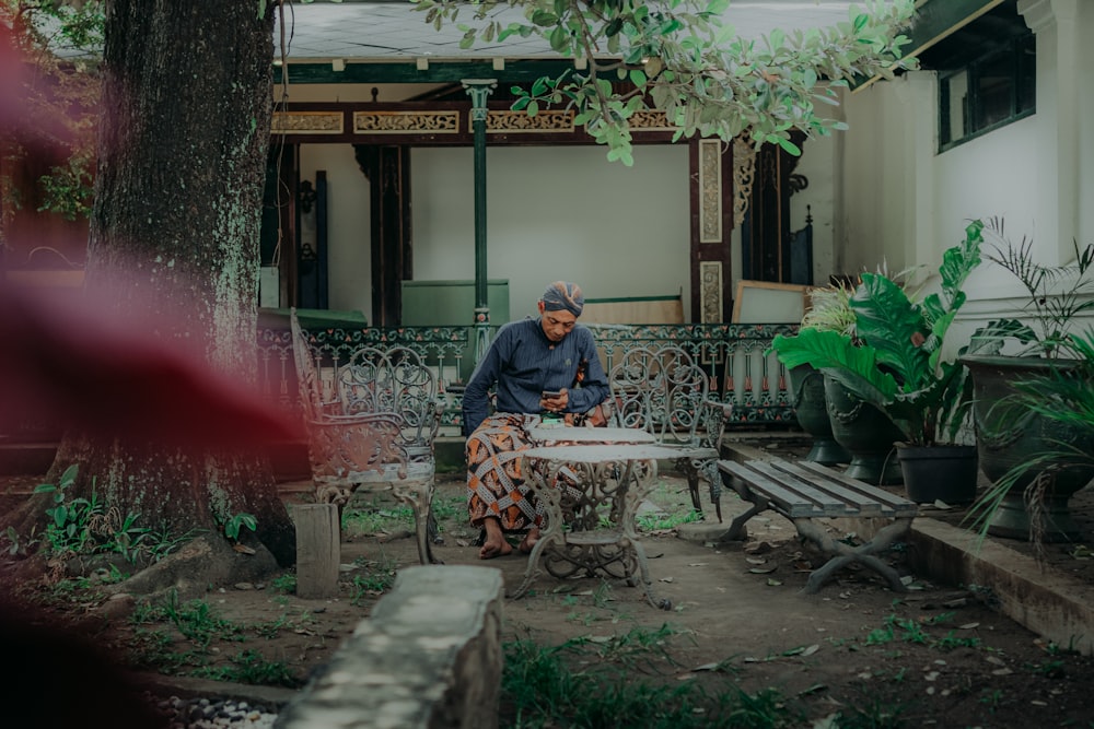 a man sitting at a table in a courtyard