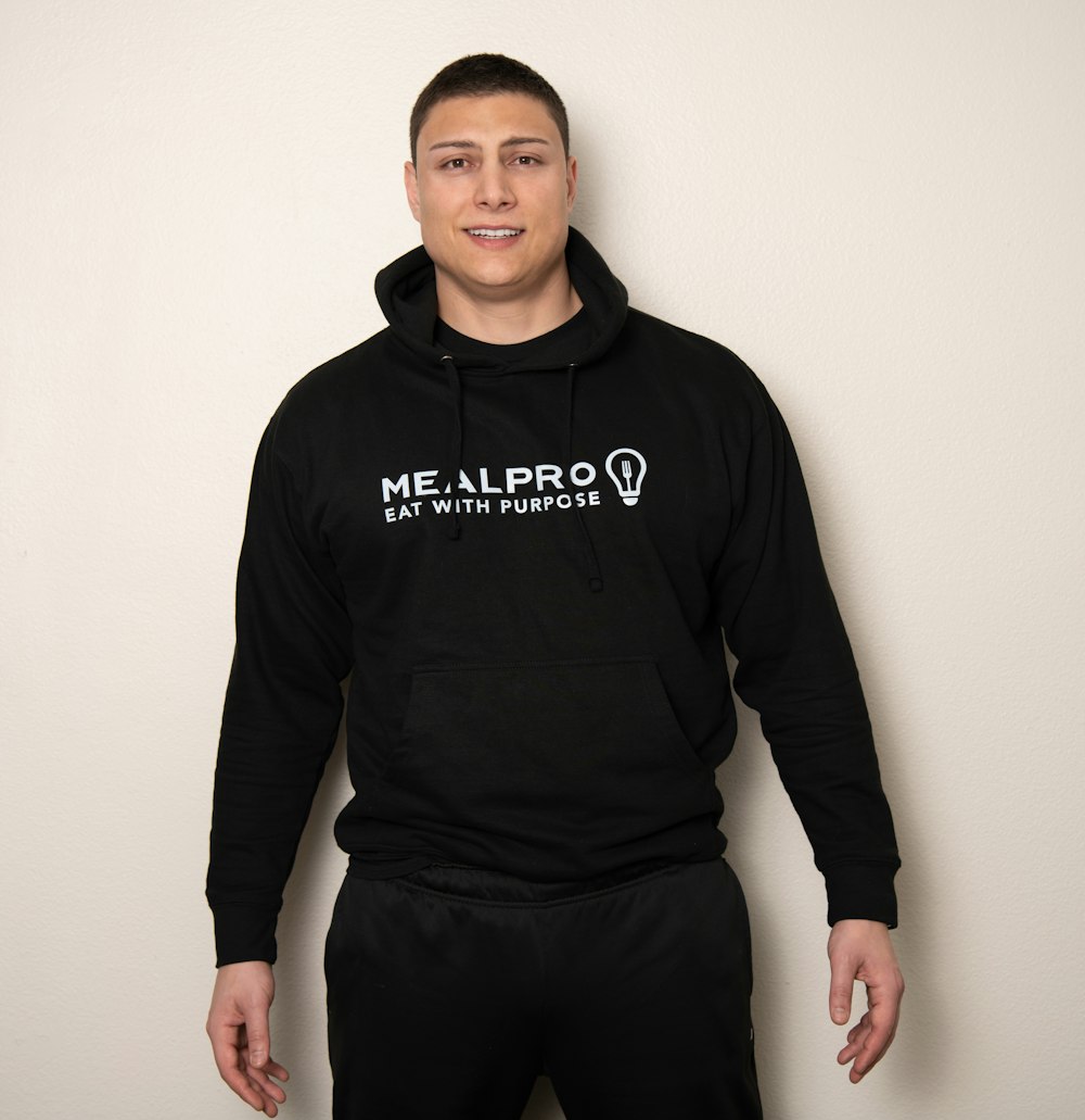 a man in a black hoodie is posing for a picture