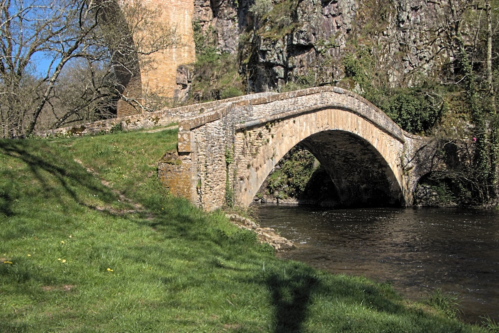 a stone bridge over a river near a castle