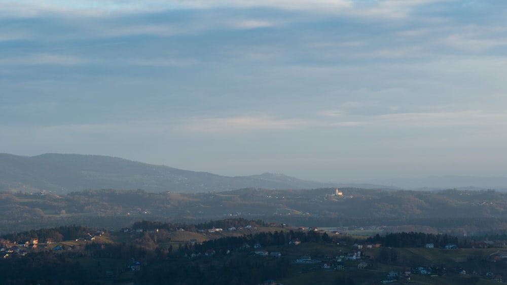 a view of a town in the distance with mountains in the background