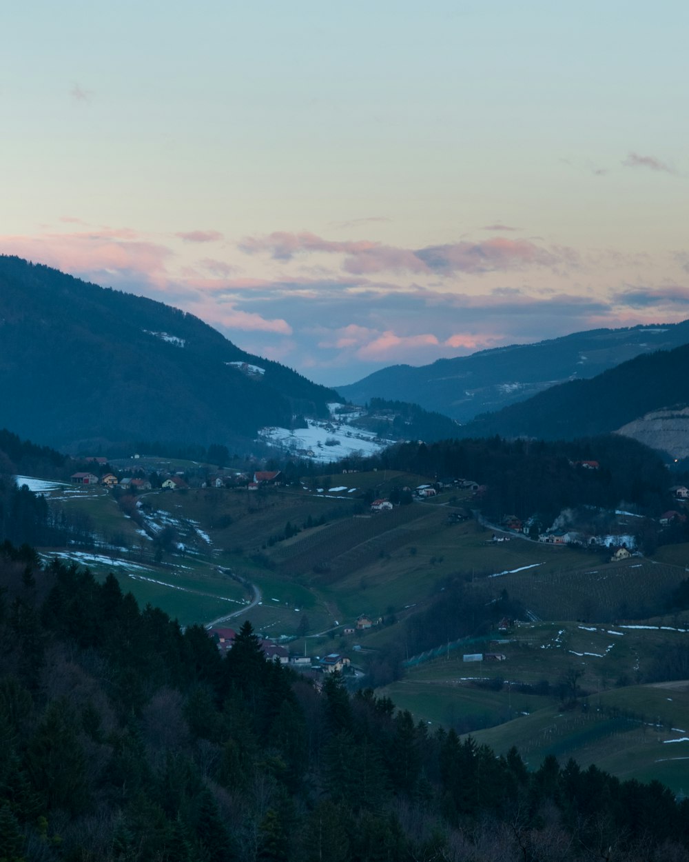 a scenic view of a valley with a mountain in the background