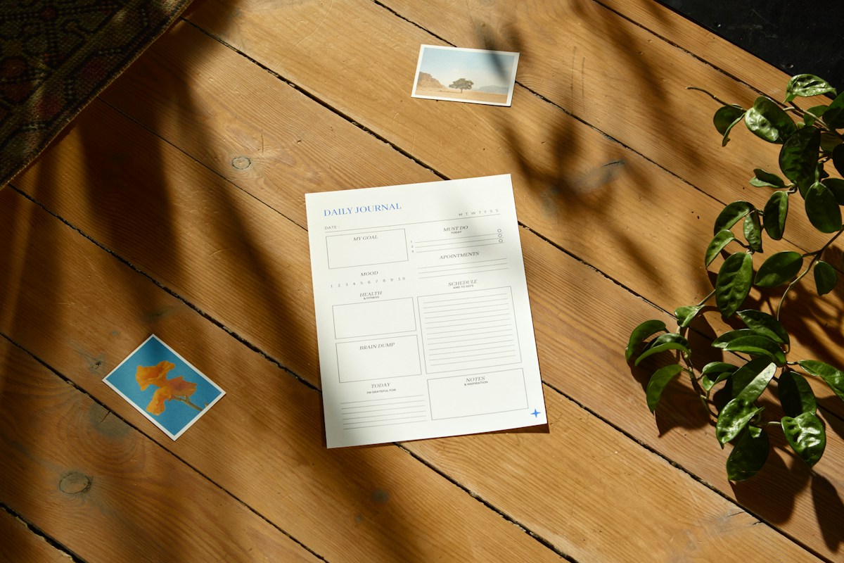 A wooden table with a potted plant and a nonprofit summer planning checklist on paper.