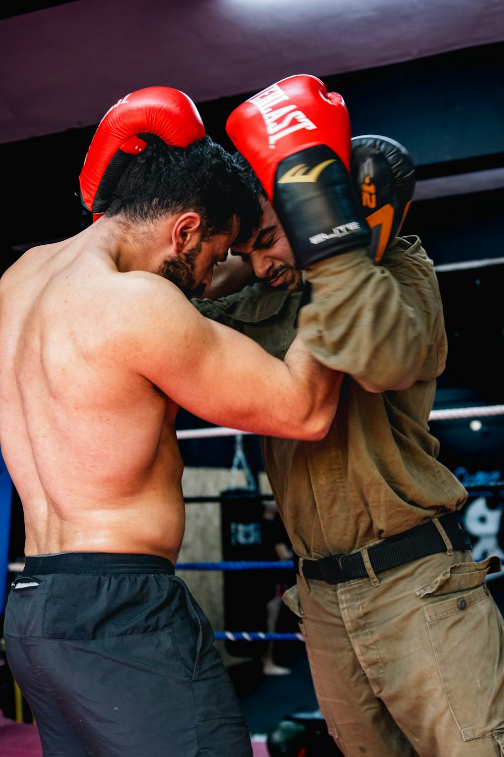 a couple of men standing next to each other in a boxing ring