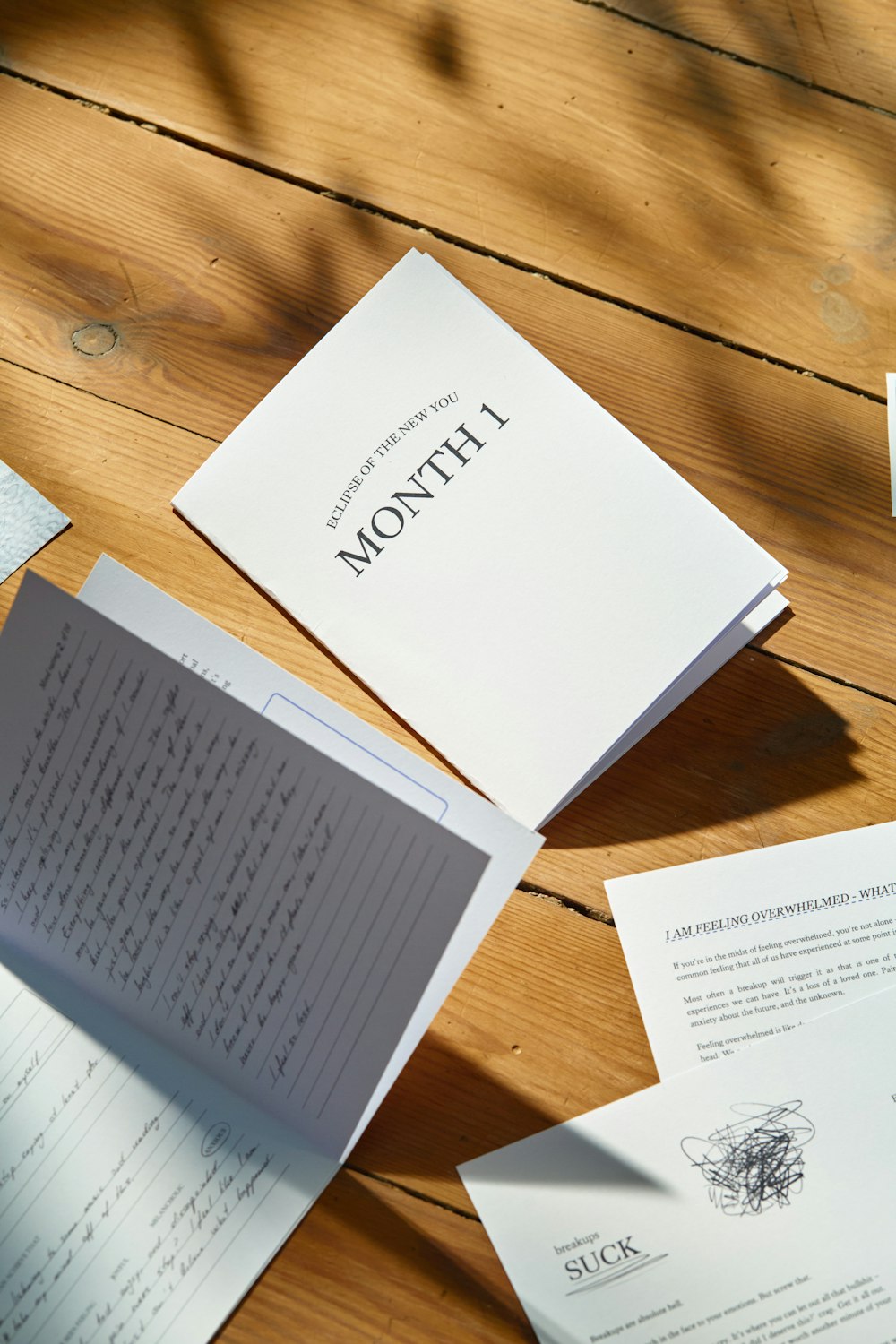 a table topped with lots of papers on top of a wooden table