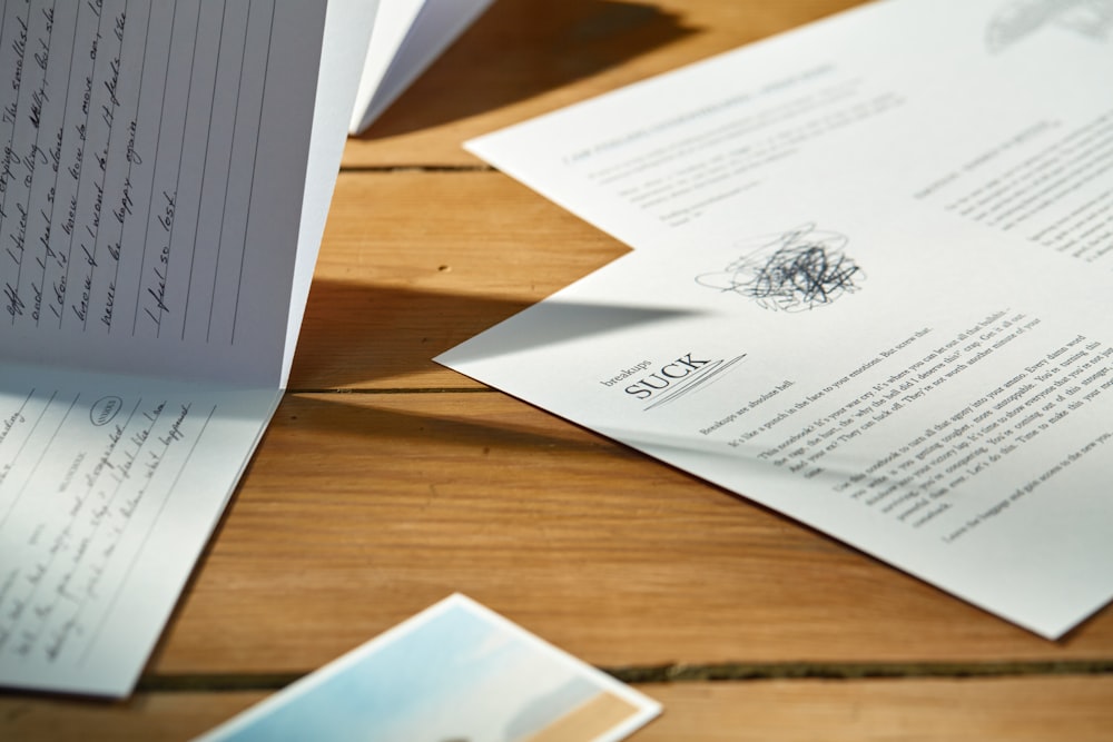 a pile of papers sitting on top of a wooden table