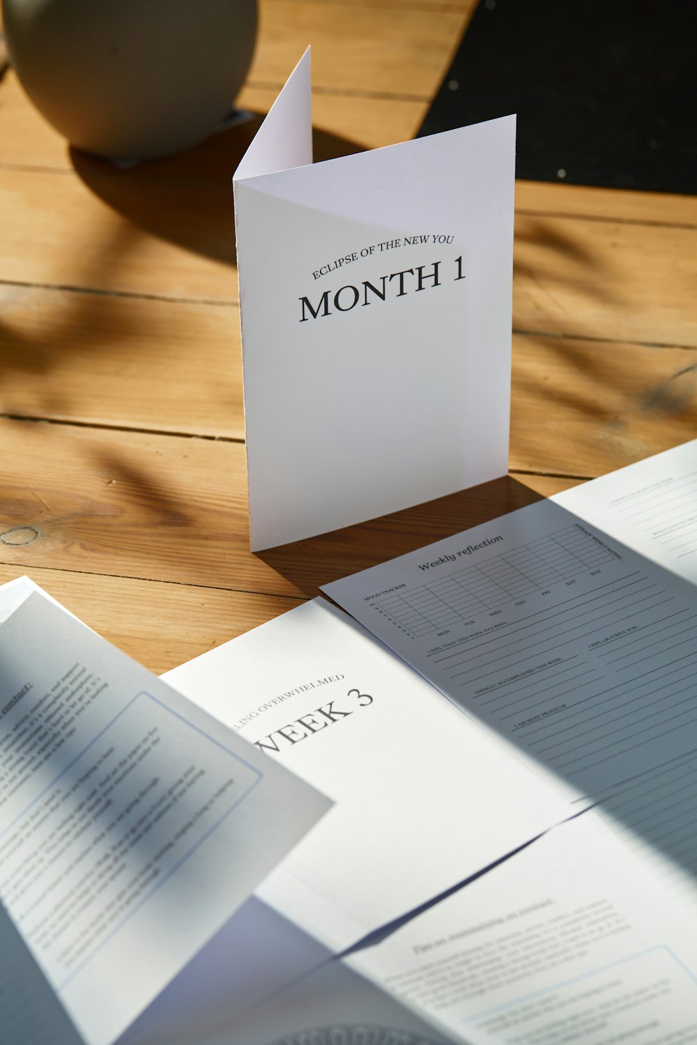 a table topped with papers and a vase