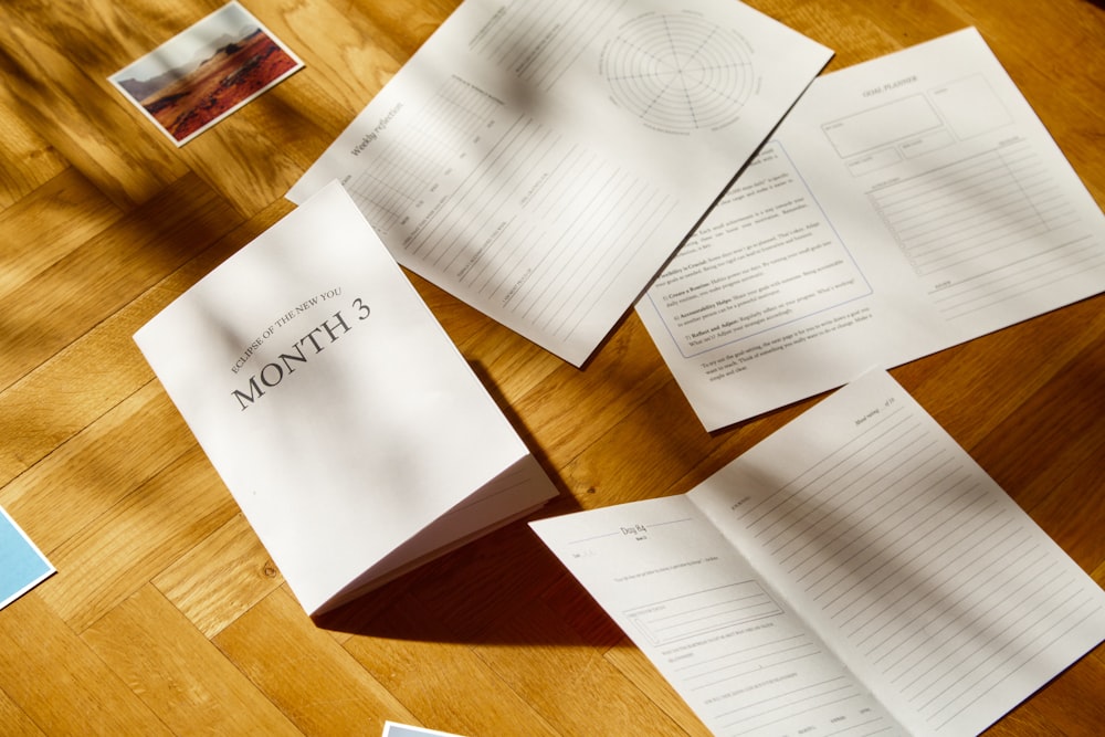 a wooden table topped with lots of papers