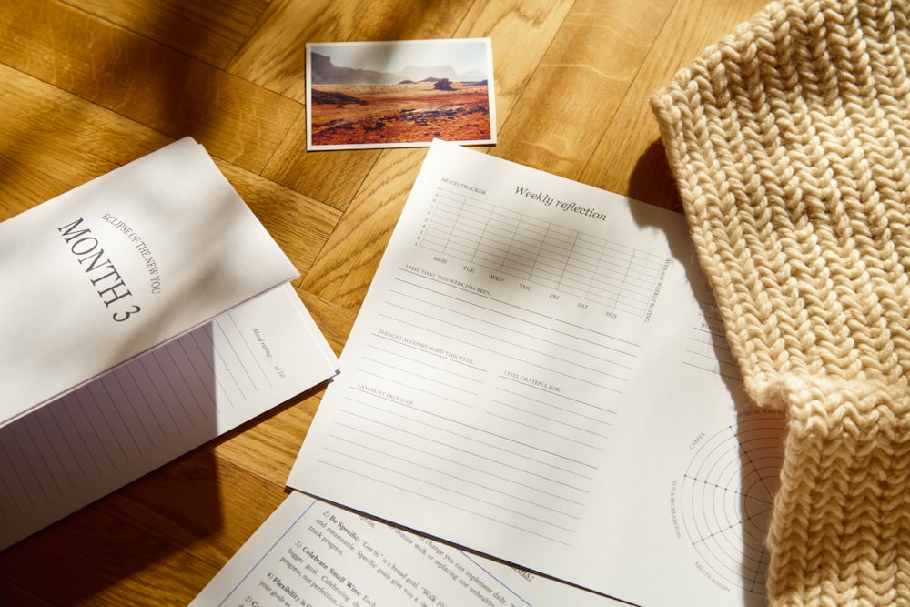 a pile of papers sitting on top of a wooden table