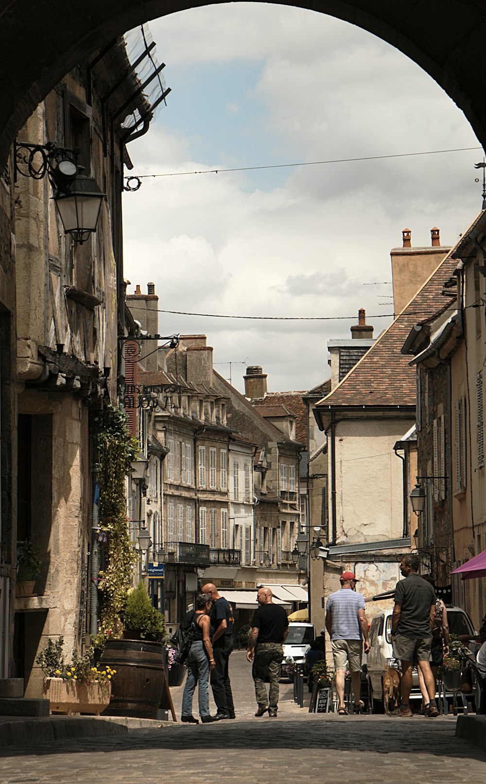 a group of people walking down a street next to tall buildings