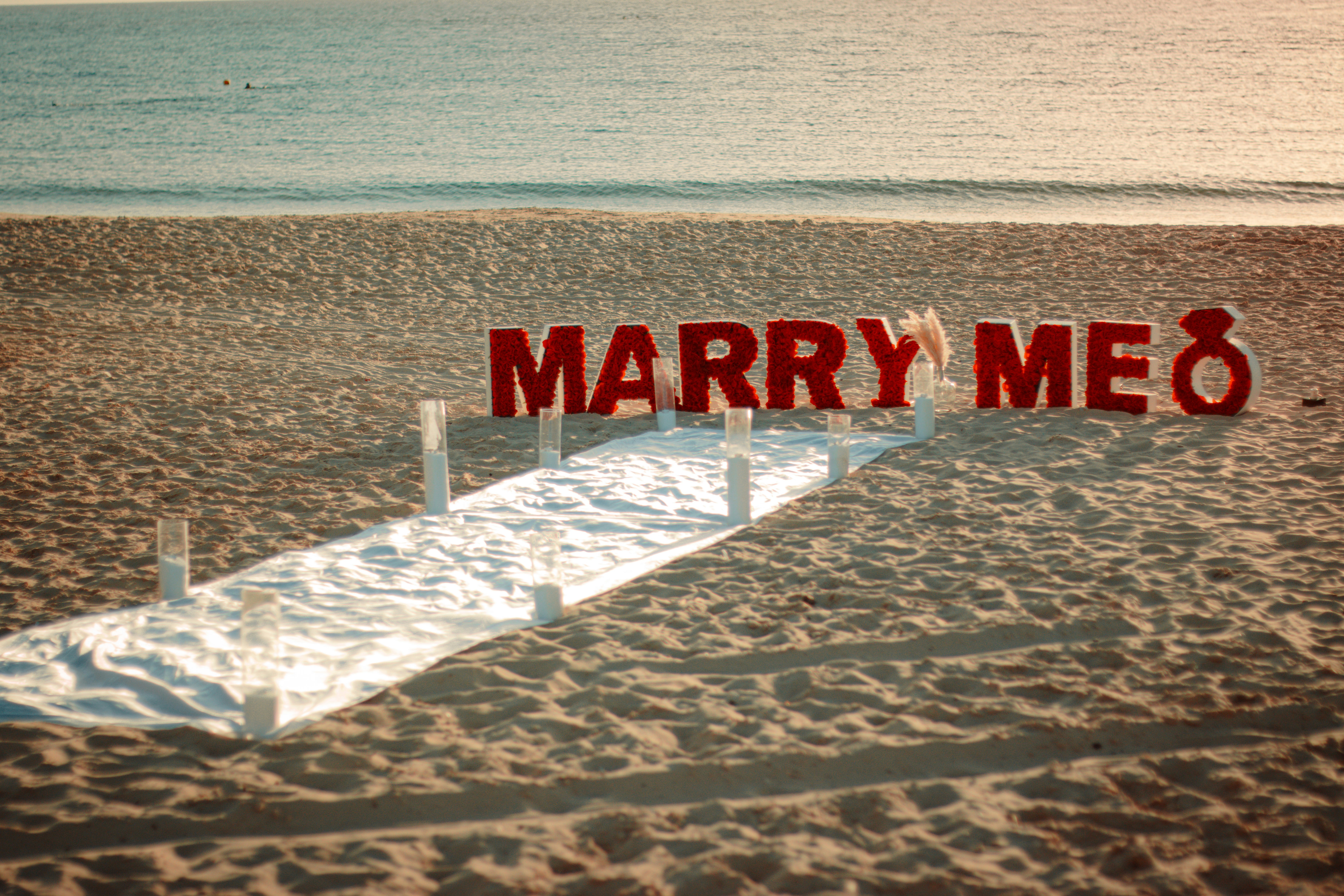 a sign that says marry me on the beach
