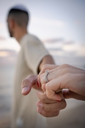 a man and a woman holding hands on the beach