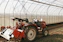 a red tractor is parked in a greenhouse