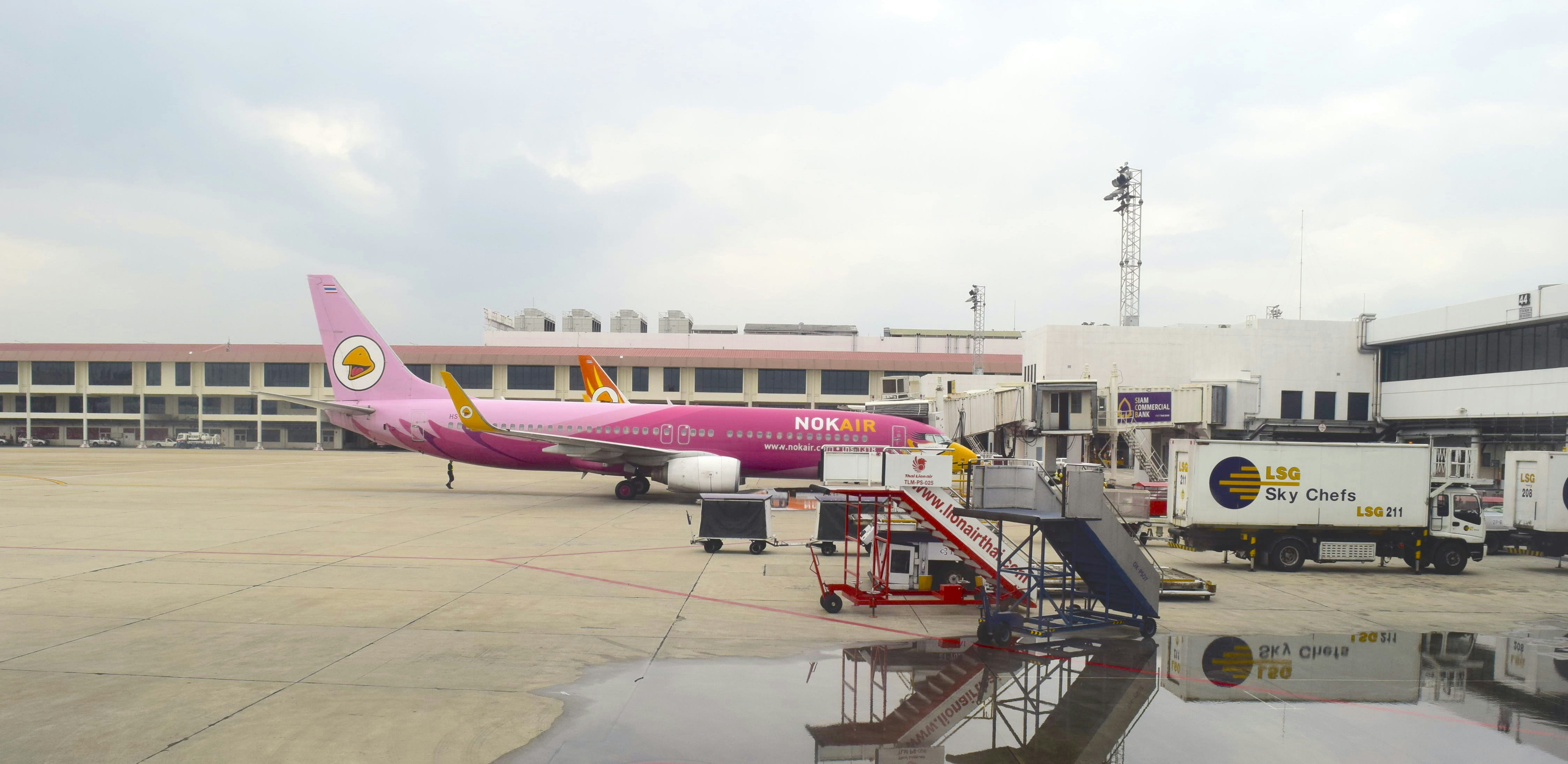 a pink airplane is parked at an airport, 