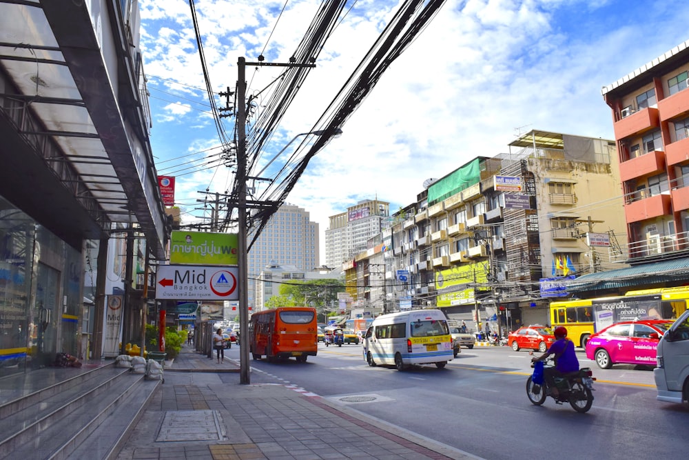 a city street filled with lots of traffic next to tall buildings