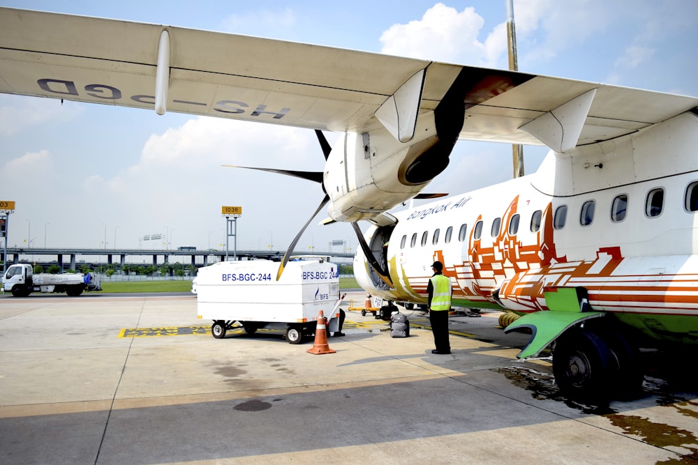 a man standing next to an airplane on a tarmac