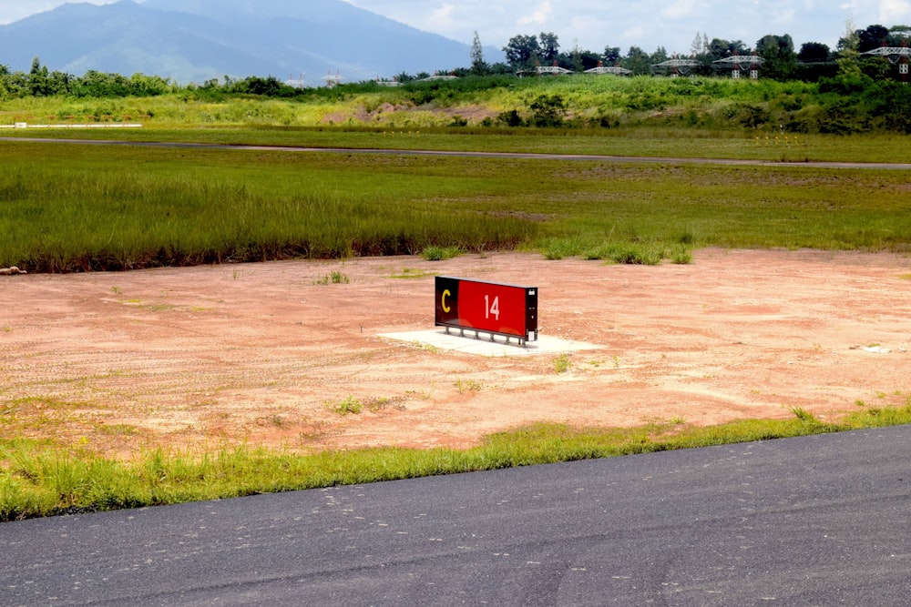 una caja roja sentada en medio de un campo