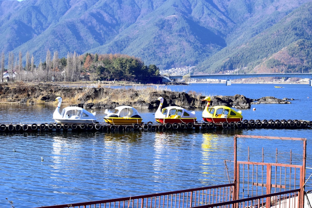 a row of boats floating on top of a lake