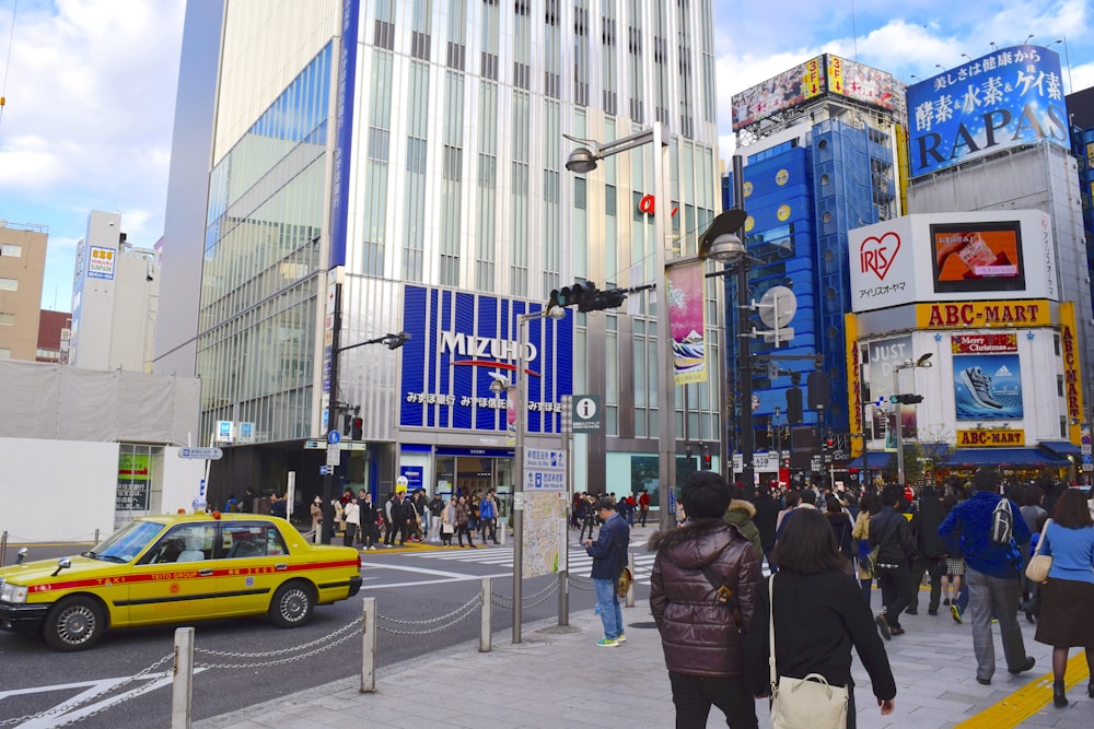 a group of people walking down a street next to tall buildings